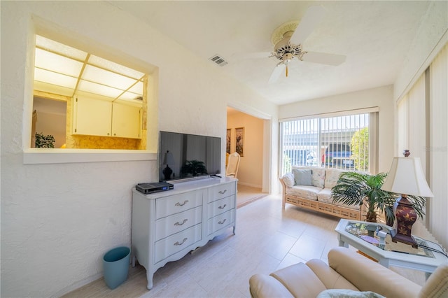 tiled living room with ceiling fan