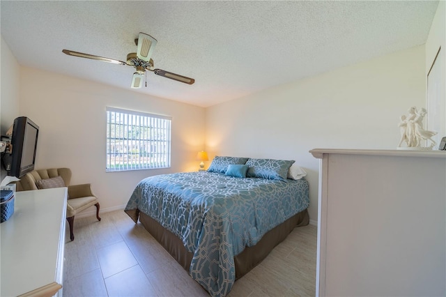 bedroom with light tile floors, ceiling fan, and a textured ceiling