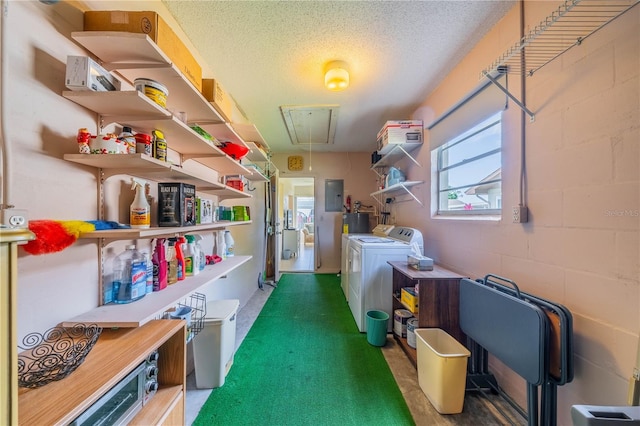 storage room with washer and clothes dryer and electric water heater