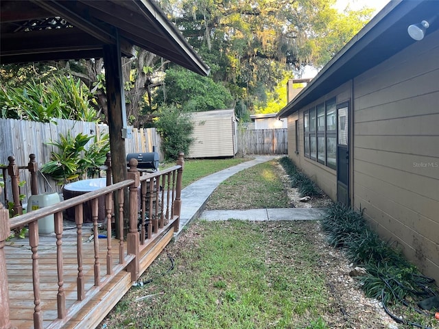 view of yard with a deck and a storage unit