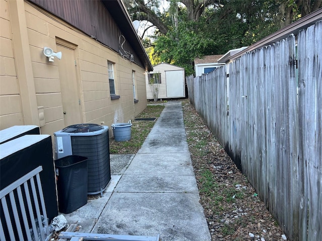 view of property exterior with central AC unit and a storage shed