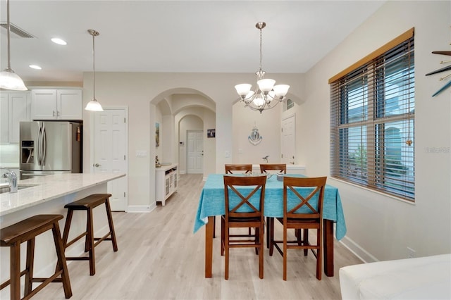 dining room featuring a notable chandelier, light hardwood / wood-style floors, and sink