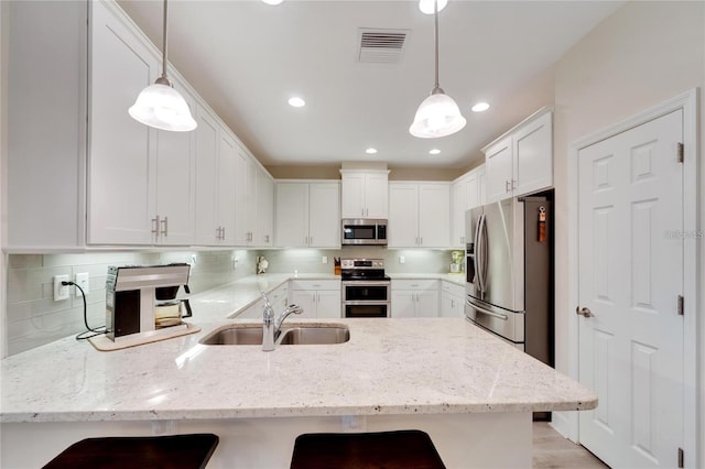 kitchen featuring pendant lighting, tasteful backsplash, appliances with stainless steel finishes, and a breakfast bar