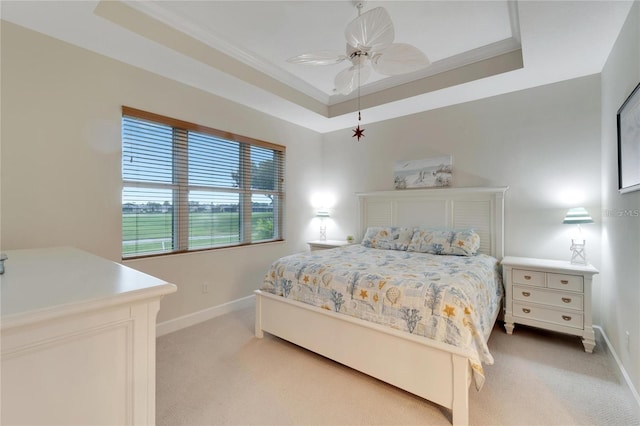 carpeted bedroom featuring ceiling fan and a raised ceiling