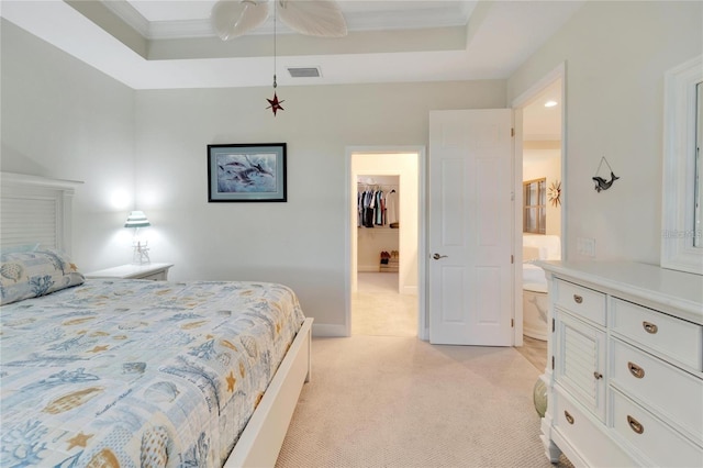 carpeted bedroom featuring a closet, ceiling fan, a spacious closet, a raised ceiling, and ornamental molding