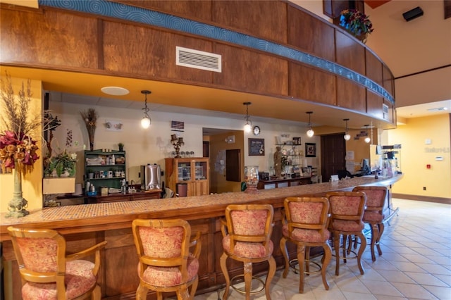 bar featuring pendant lighting and light tile floors