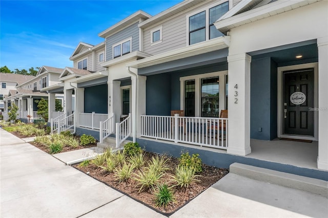 view of exterior entry featuring a porch and a residential view