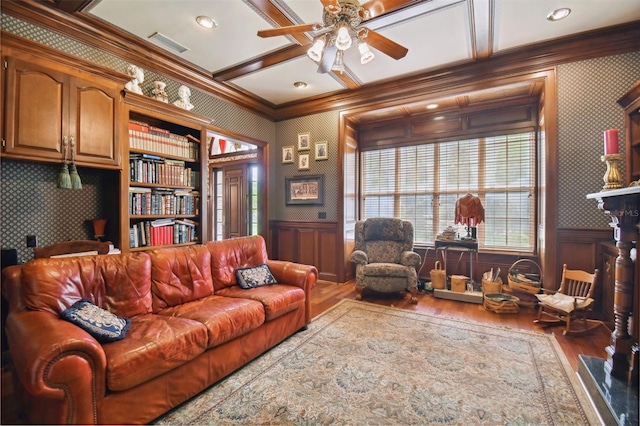 living room with coffered ceiling, hardwood / wood-style flooring, ornamental molding, and ceiling fan