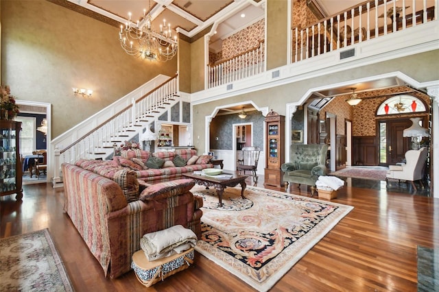 living room featuring hardwood / wood-style flooring, a high ceiling, coffered ceiling, and beam ceiling