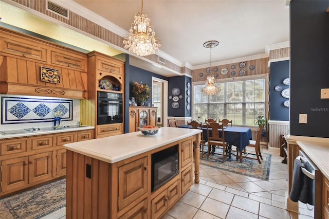 kitchen with hanging light fixtures, a notable chandelier, black appliances, and a center island