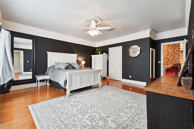 bedroom featuring wood-type flooring, crown molding, a textured ceiling, and ceiling fan