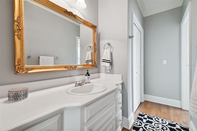 bathroom with ornamental molding, vanity, and hardwood / wood-style floors