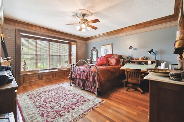 bedroom featuring crown molding, wood-type flooring, and a textured ceiling