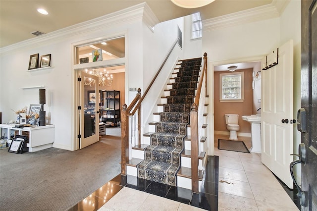 interior space with crown molding, a towering ceiling, tile patterned floors, and a notable chandelier