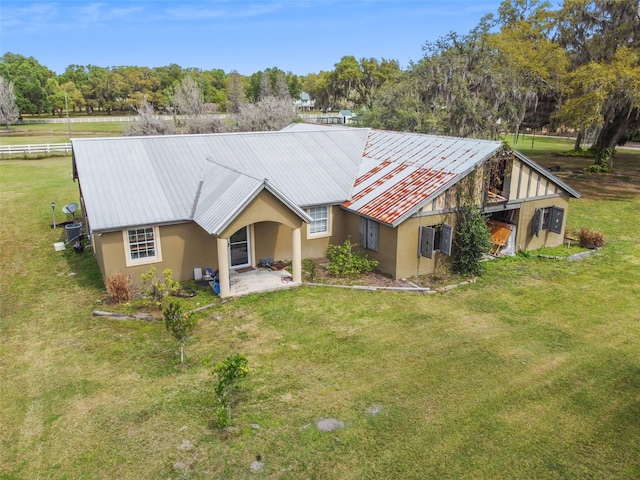 rear view of property with central AC unit and a lawn