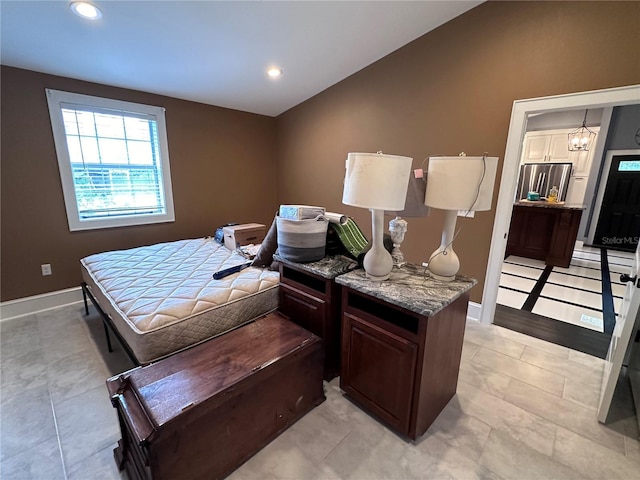 bedroom with lofted ceiling and stainless steel fridge