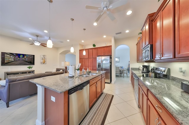 kitchen featuring pendant lighting, an island with sink, stainless steel appliances, light stone counters, and light tile patterned flooring