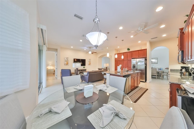 tiled dining space with ceiling fan and sink