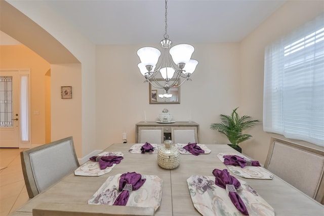 tiled dining area featuring a chandelier