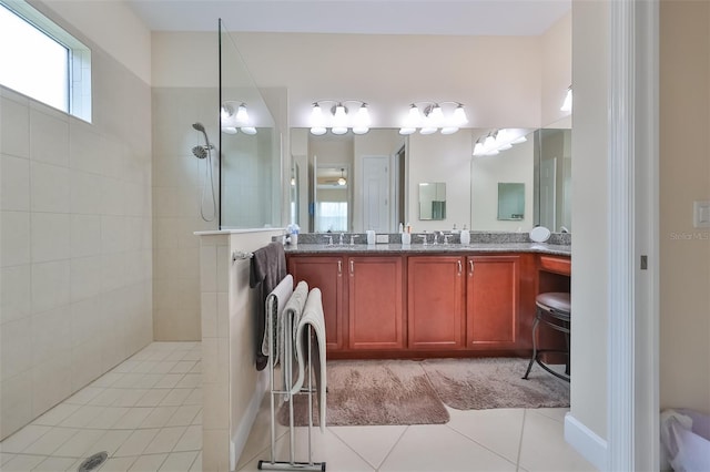 bathroom featuring a tile shower, tile patterned floors, and vanity