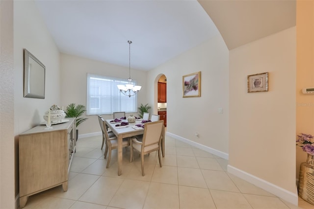 tiled dining space featuring an inviting chandelier