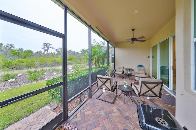 sunroom featuring ceiling fan and plenty of natural light