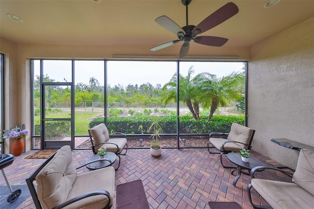 sunroom / solarium featuring ceiling fan