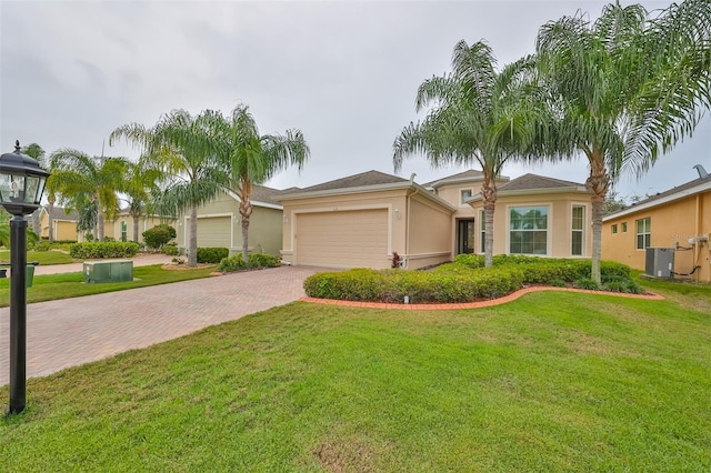 view of front of house featuring a garage, cooling unit, and a front yard