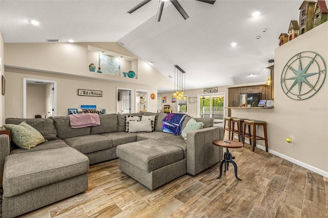 living room with high vaulted ceiling, light hardwood / wood-style floors, ceiling fan, and a textured ceiling