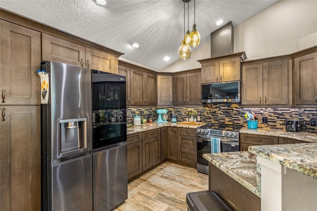 kitchen featuring light hardwood / wood-style floors, light stone countertops, backsplash, and stainless steel appliances