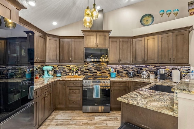 kitchen featuring appliances with stainless steel finishes, tasteful backsplash, and light stone counters