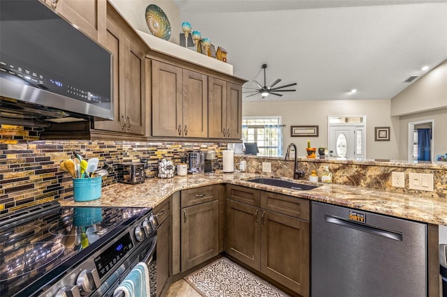 kitchen with kitchen peninsula, stainless steel appliances, ceiling fan, and light tile floors