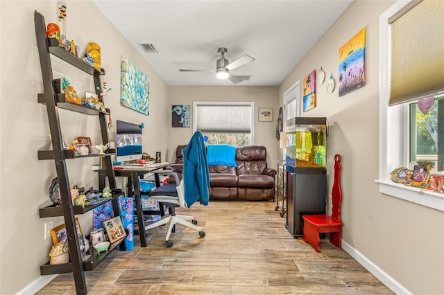 office with light hardwood / wood-style flooring and ceiling fan