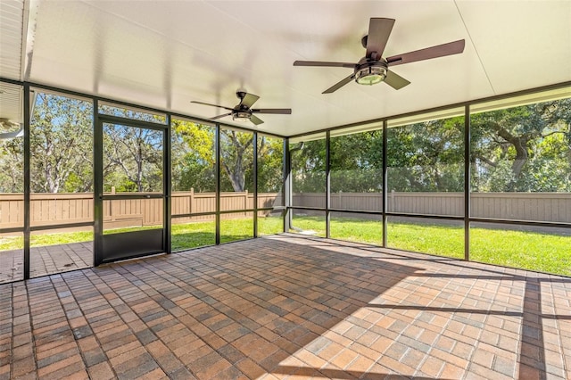 unfurnished sunroom featuring ceiling fan