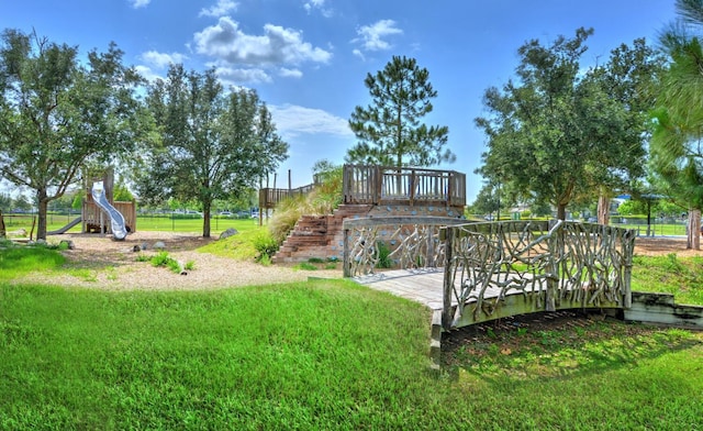 view of playground with a yard and a deck