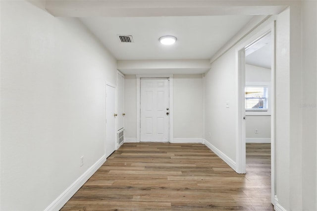 spare room featuring vaulted ceiling and hardwood / wood-style floors