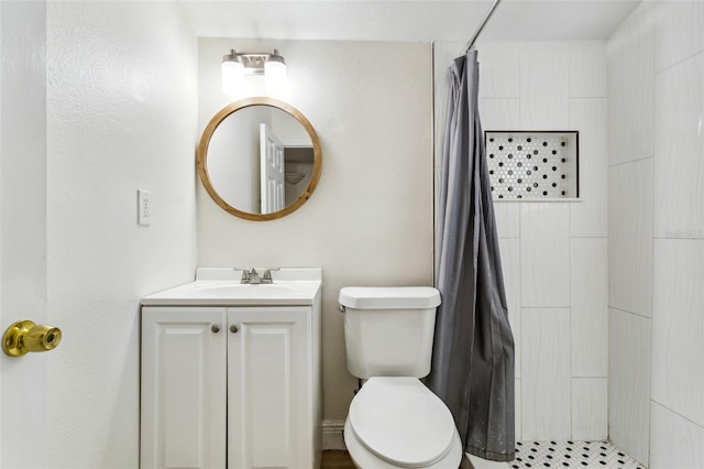 bathroom featuring toilet, vanity, and walk in shower