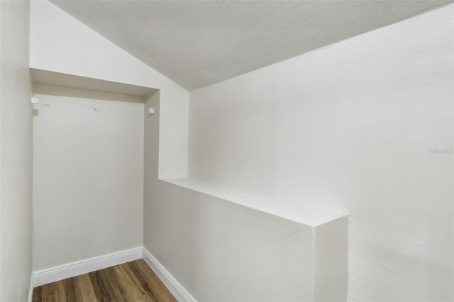 interior space with a textured ceiling, lofted ceiling, and hardwood / wood-style floors