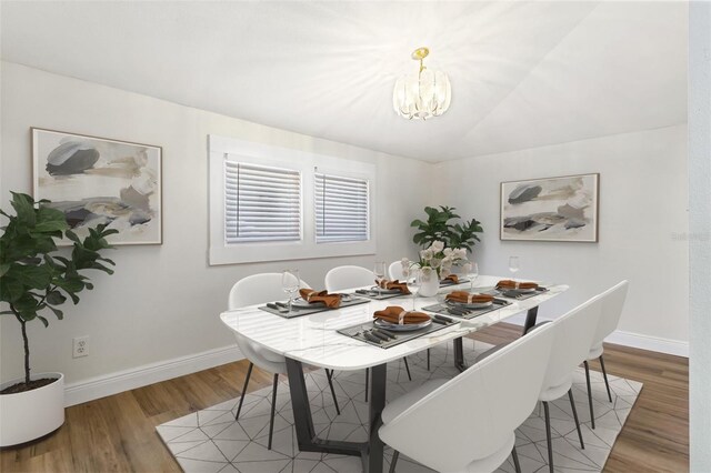 dining area featuring hardwood / wood-style flooring and a notable chandelier