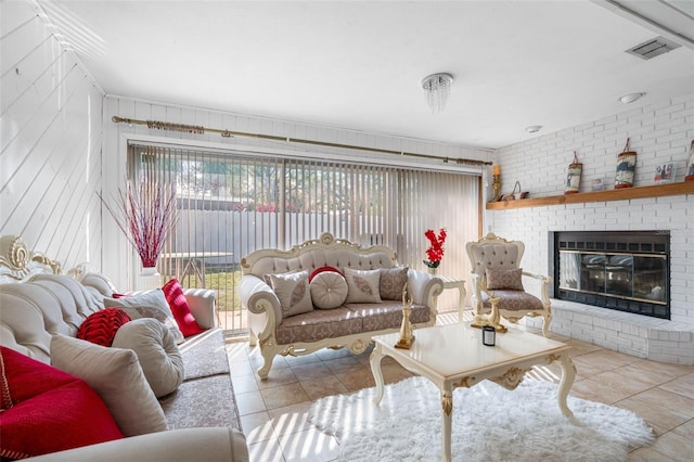 tiled living room with brick wall and a brick fireplace