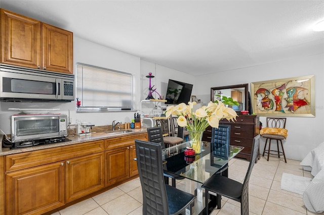 kitchen featuring light stone countertops, sink, and light tile patterned floors