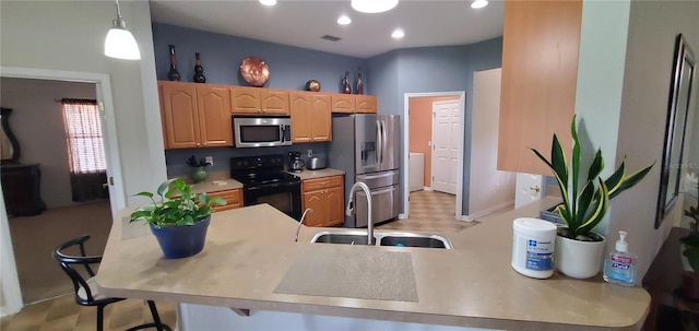 kitchen with a breakfast bar area, pendant lighting, appliances with stainless steel finishes, and sink