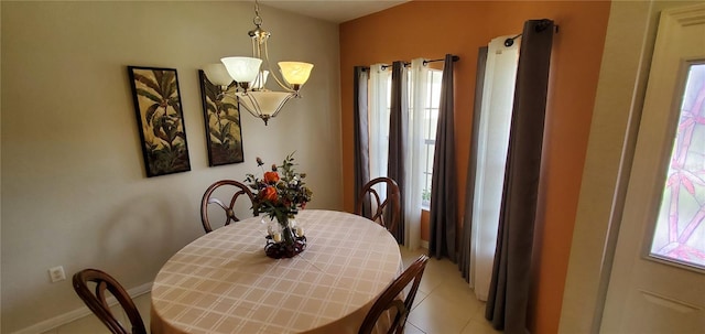 tiled dining room with an inviting chandelier