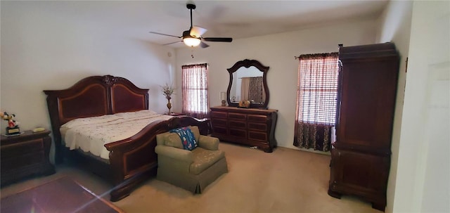 bedroom with light colored carpet, ceiling fan, and multiple windows