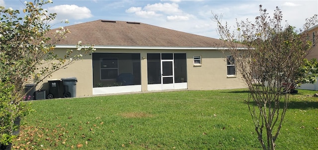 back of property featuring a yard and a sunroom