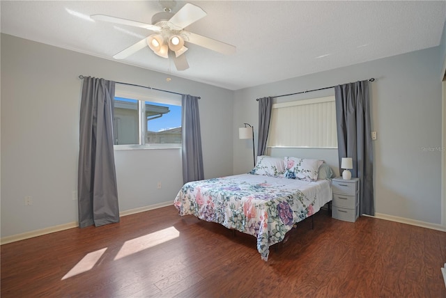 bedroom with a textured ceiling, ceiling fan, and dark wood-type flooring