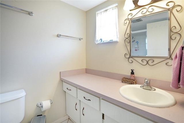 bathroom with visible vents, toilet, and vanity