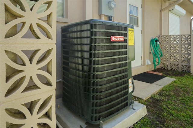 details featuring central air condition unit, electric meter, and stucco siding