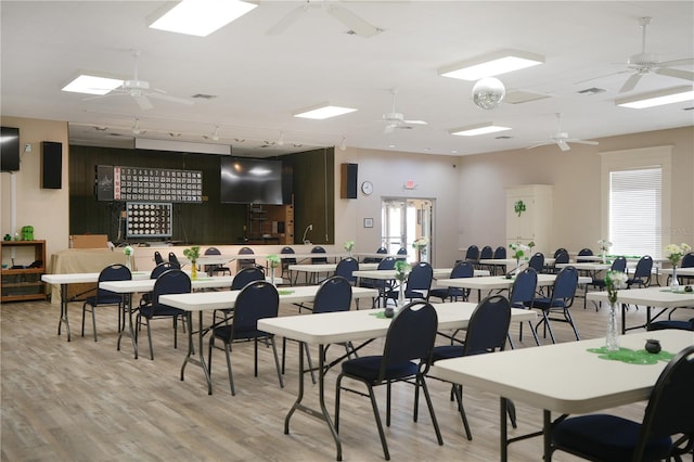 dining space featuring light wood-style flooring, rail lighting, visible vents, and ceiling fan