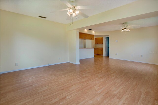 empty room with ceiling fan and light hardwood / wood-style flooring